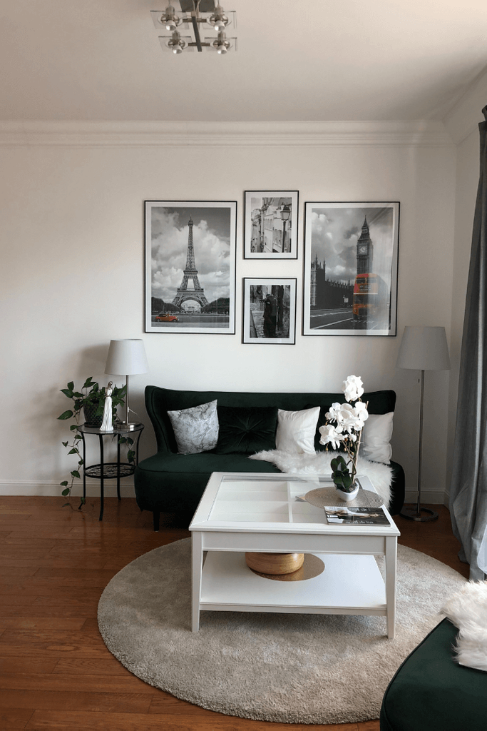wnętrze w stylu glamour, zielona sofa, biały stolik do salonu, stylizowane meble, obrazy na ścianie