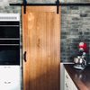 solidne drewniane drzwi przesuwne w kuchni, przesuwne drzwi do spiżarni, cegła na ścianie w kuchni