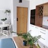 drzwi drewniane w metalowej ramie, drzwi przesuwne w przedpokoju, drzwi z litego drewna, nowoczesne jasne wnętrze, kuchnia z jadalnią, białe meble w kuchni