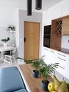 drzwi drewniane w metalowej ramie, drzwi przesuwne w przedpokoju, drzwi z litego drewna, nowoczesne jasne wnętrze, kuchnia z jadalnią, białe meble w kuchni