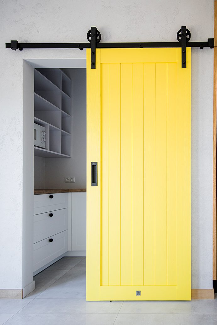 żółte drzwi przesuwne, przesuwne drzwi do schowka, unikalny system przesuwny, żółte drzwi, nowoczesna kuchnia, wejście do spiżarni, żółte drzwi drewniane