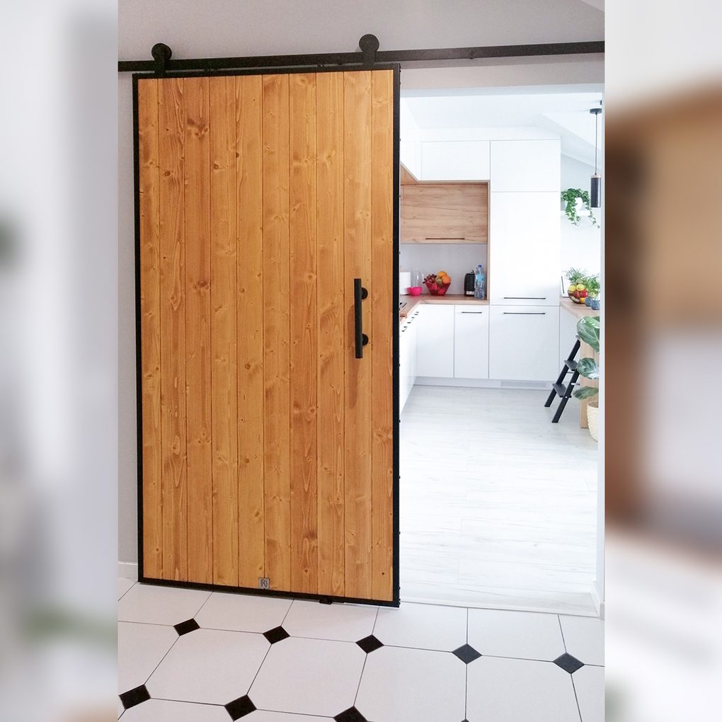 Loftowe drzwi przesuwne z drewna i stali w nowoczesnej kuchni