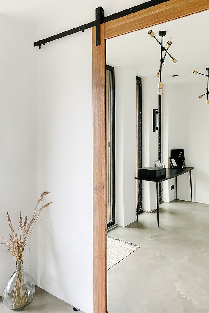 Industrialny żyrandol i czarny minimalistyczny stolik w odbiciu lustrzanym