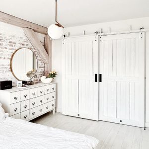 białe podwójne drzwi przesuwne w sypialni urządzonej w kolorach bieli