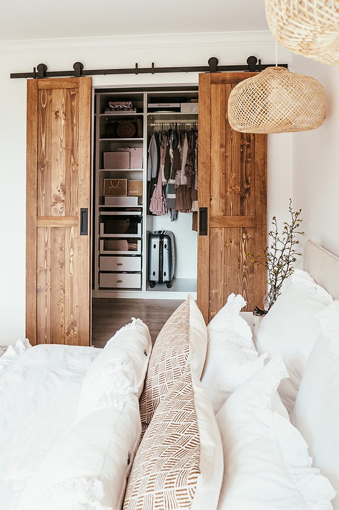 Wąskie drzwi drewniane do garderoby w boho sypialni