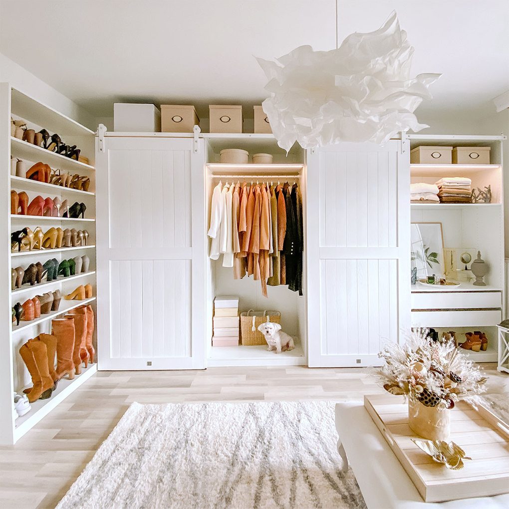 Białe drewniane drzwi przesuwne do szafy w aranżacji dużej garderoby w sylu klasycznym