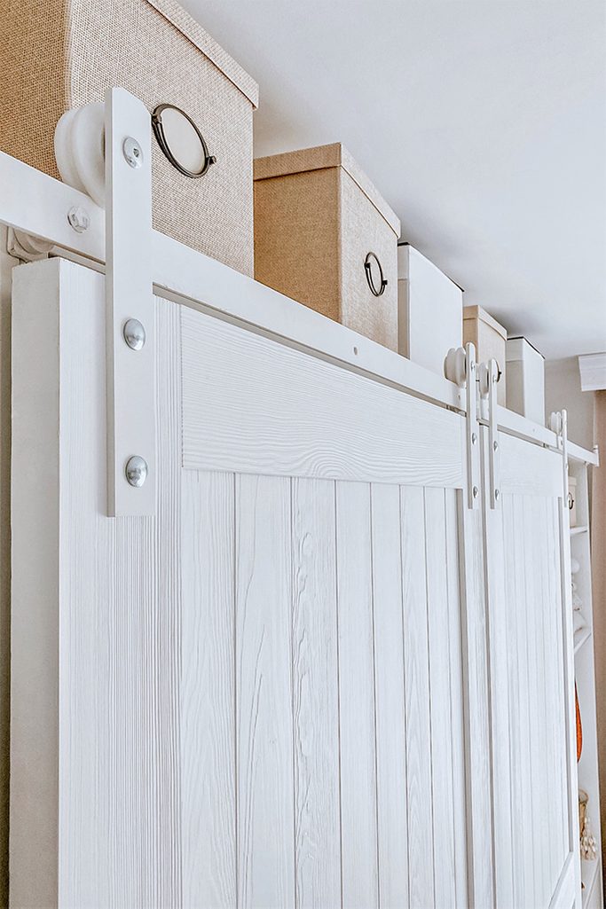 Białe drewniane drzwi na białym systemie przesuwnym