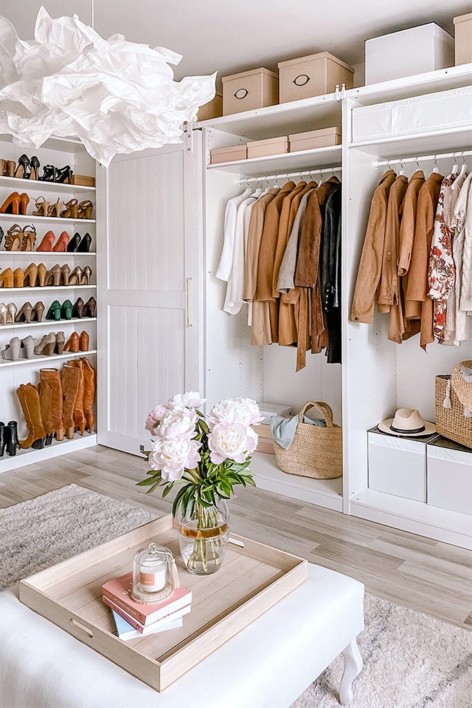 Duży pokój z otwartymi szafami ukazującymi ubrania oraz półkami wypełnionymi damskimi butami