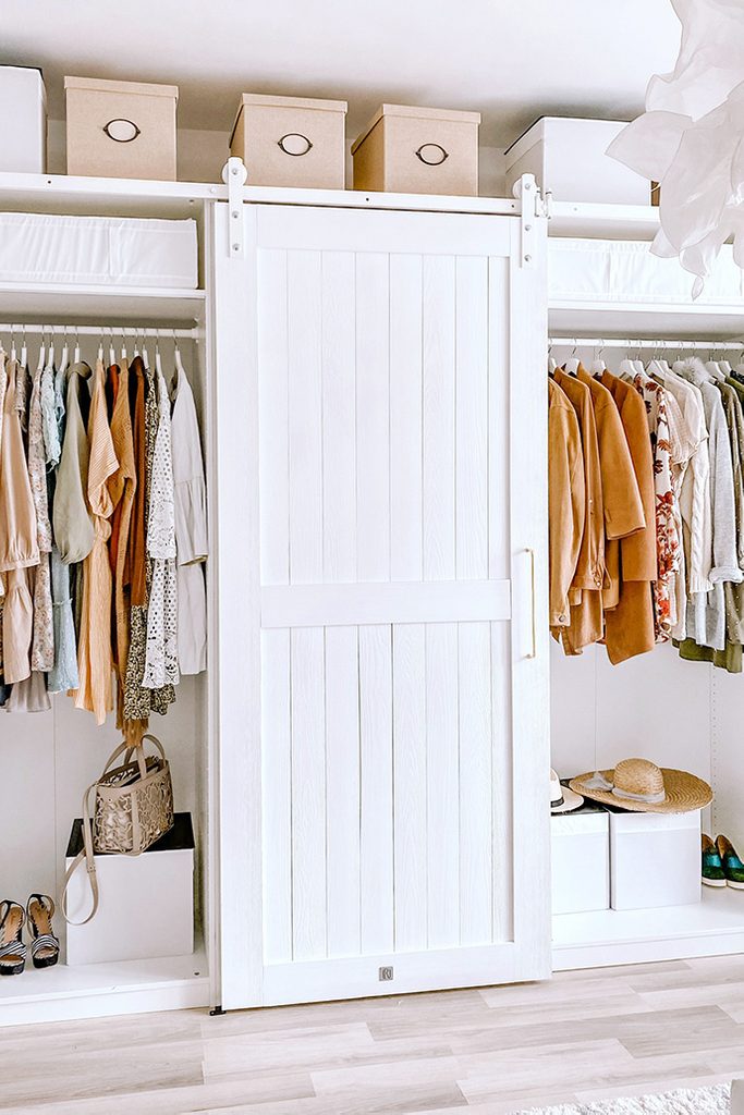 Białe, drewniane drzwi na systemie przesuwnych zamykające szafy z ubraniami