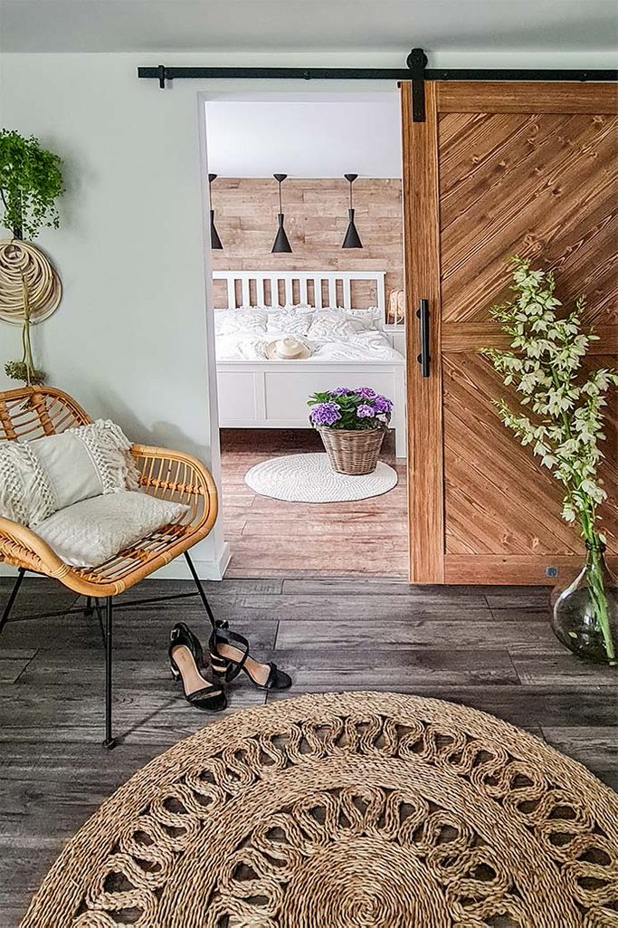 skandynawskie wnętrze sypialni znajdującej się za drewnianymi drzwiami przesuwnymi