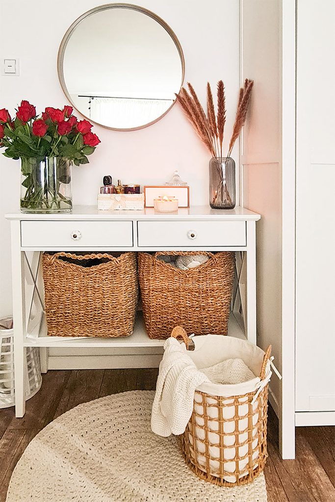 biała komoda i wiklinowe kosze na pościel w skandynawskim wnętrzu