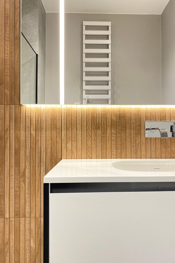 nowoczesna łazienka z białą armaturą i płytkami w kolorze drewna