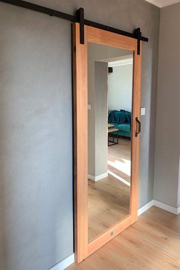 Drewniane drzwi przesuwne z lustrem w przedpokoju