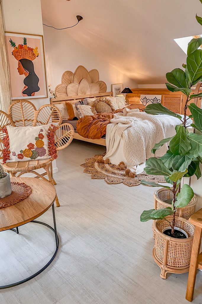 drewniane łóżko z dekoracyjnym zagłówkiem i boho poduszkami