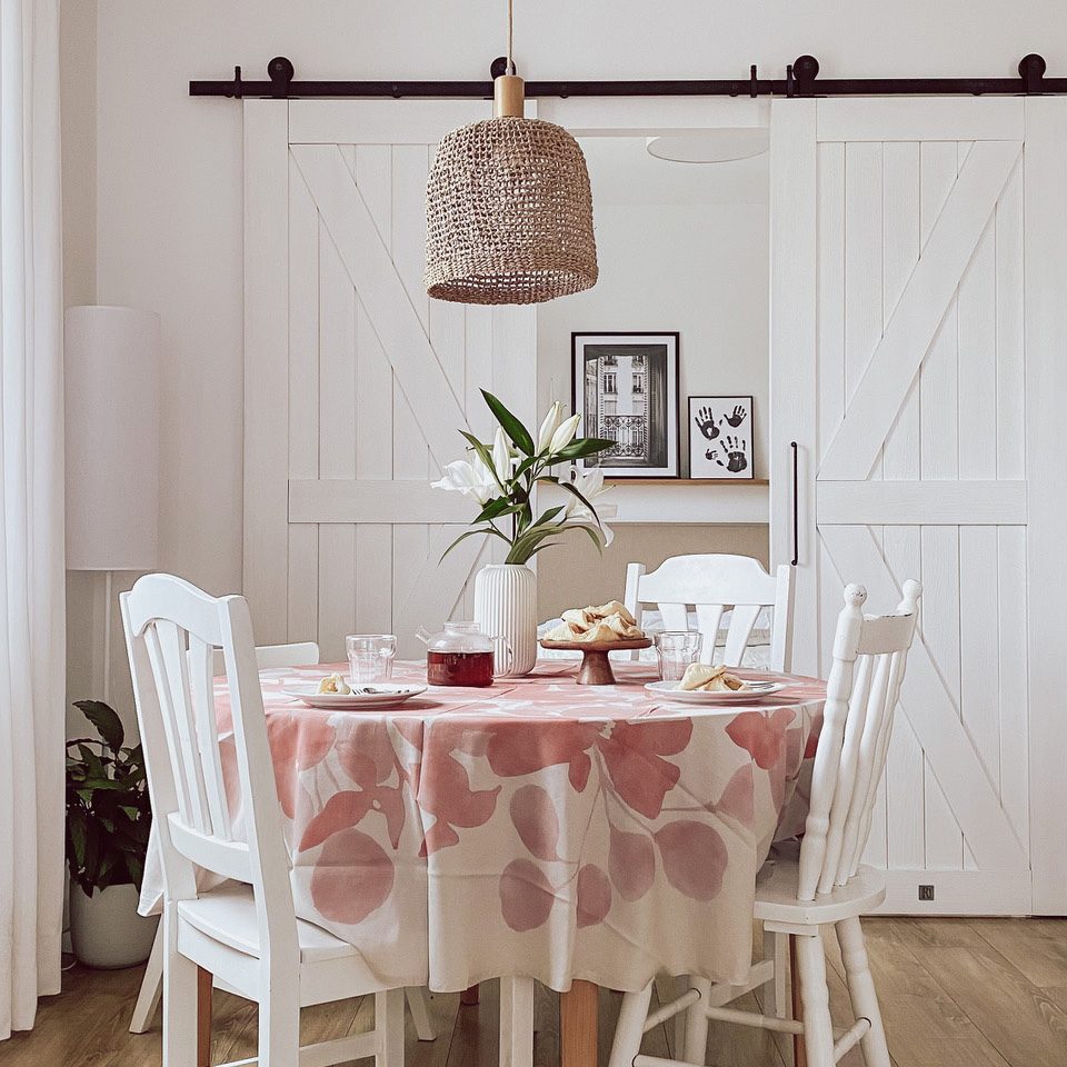 białe krzesła przy okrągłym stole na tle podwójnych białych drzwi przesuwnych prowadzących do sypialni