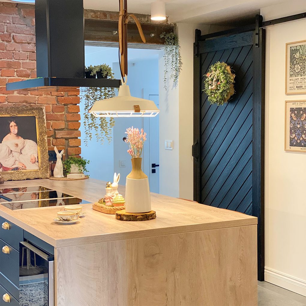 kuchnia ze spiżarnią z czarnymi drzwiami przesuwnymi