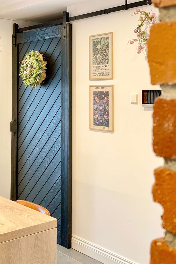 czarne, drewniane drzwi przesuwne zamykające wnękę ze spiżarnią