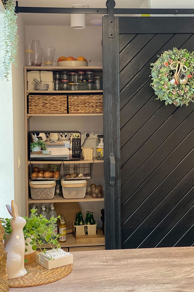 czarne drzwi przesuwne zamykające spiżarnię w kuchni
