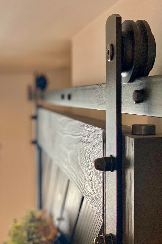 czarne drzwi i czarny system przesuwny w wejściu do spiżarni