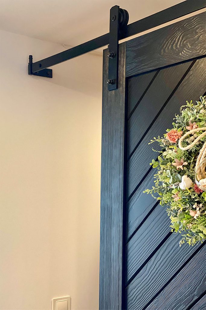 czarne drzwi i czarny system przesuwny w wejściu do spiżarni