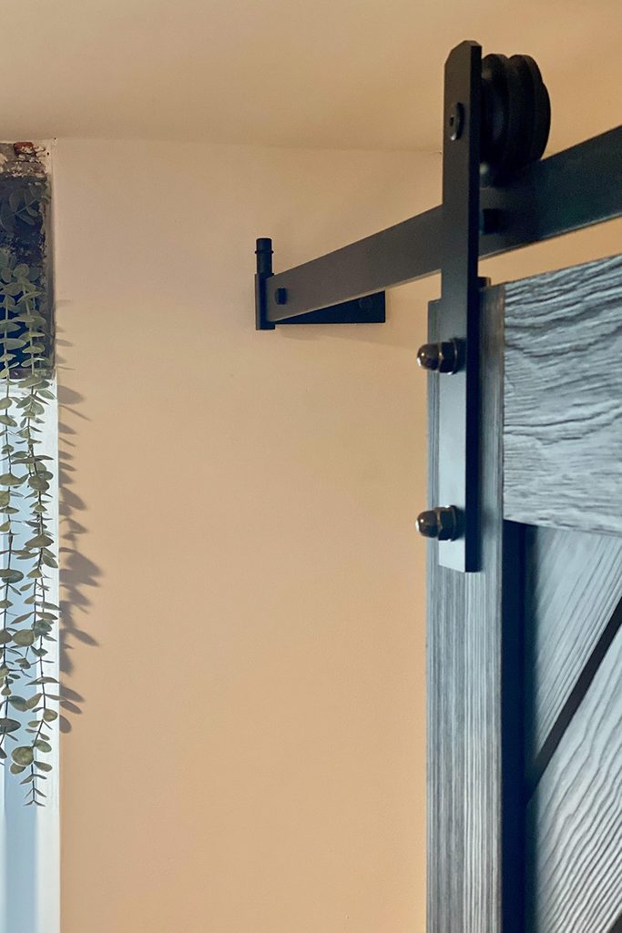 czarne drzwi i czarny system przesuwny w wejściu do spiżarni