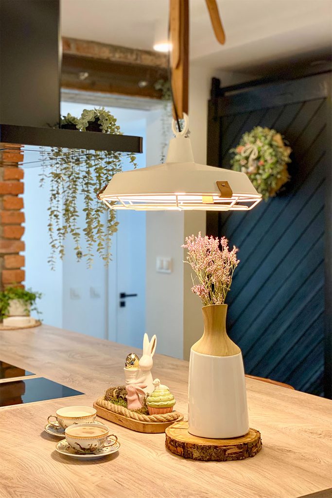 metalowa lampa na skórzanych paskach wisząca w kuchni nad blatem