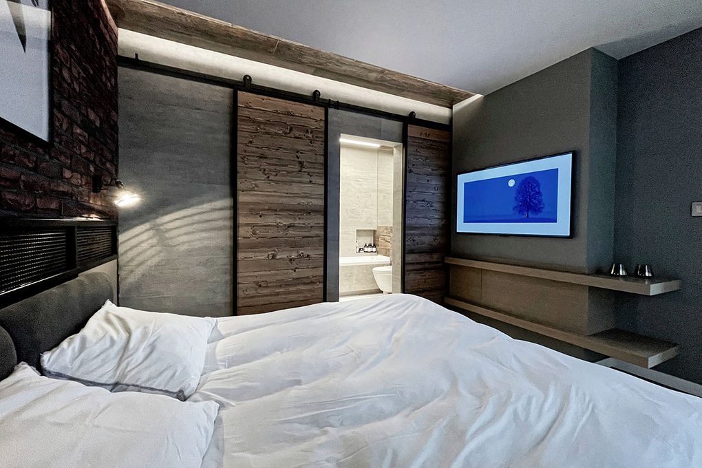 drzwi przesuwne do łazienki w sypialni urządzonej w stylu loftowym