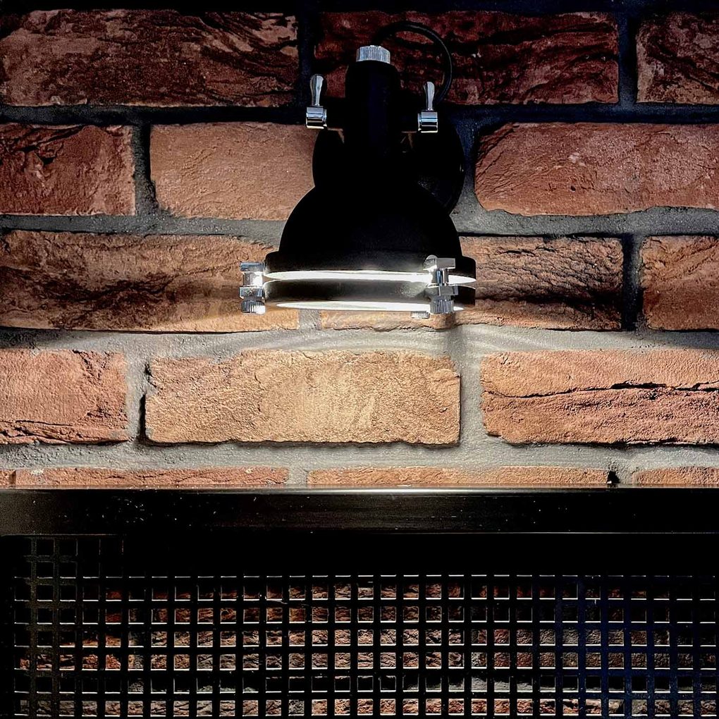 metalowa lampka industrialna na ścianie z czerwonej cegły