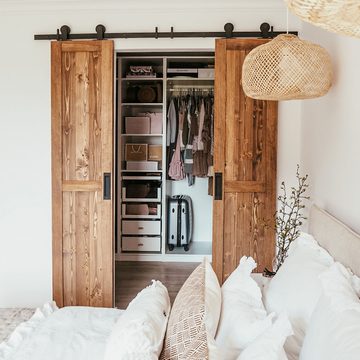 Wąskie drzwi przesuwne z litego drewna do małej garderoby w sypialni