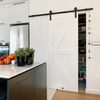 Białe drewniane drzwi przesuwne do spiżarni w nowoczesnej kuchni