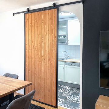 Loftowe drzwi z litego drewna w metalowej ramie w wejściu do kuchni