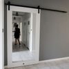 Białe drewniane drzwi przesuwne z lustrem w przedpokoju