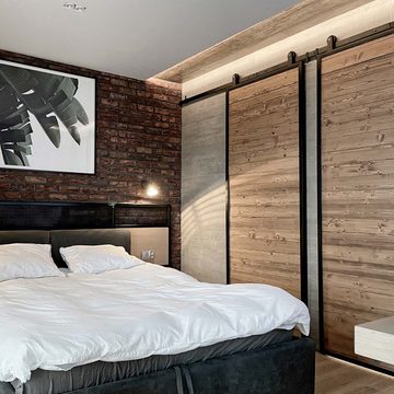 Drzwi przesuwne z litego drewna w metalowej ramie w loftowej sypialni