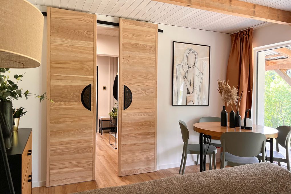 designerskie drzwi przesuwne w aranżacji pokoju gościnnego utrzymanego w naturalnej kolorystyce