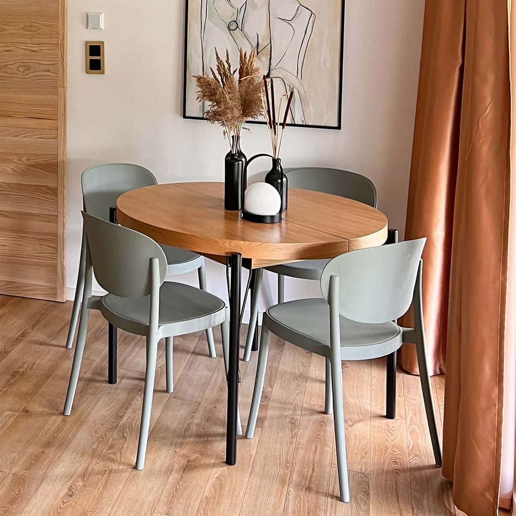 szałwiowe krzesła stojące wokół okrągłego stołu z drewnianym blatem i metalowymi nogami