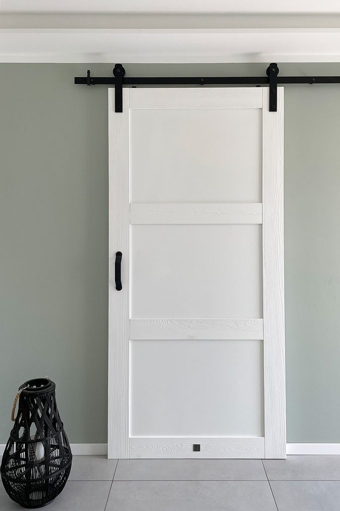 Nowoczesne białe drzwi przesuwne z czarnym systemem przesuwnym zainstalowane