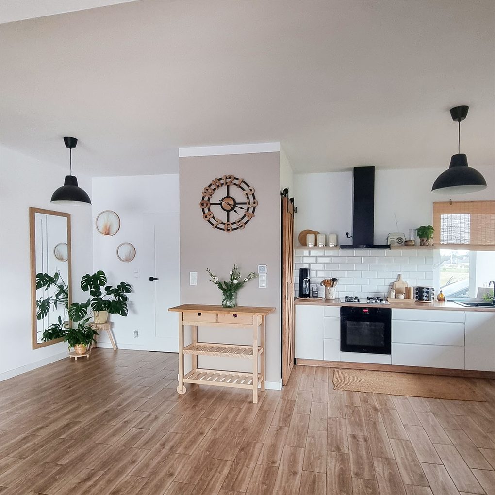 białe ściany i drewniana podłoga w skandynawskiej kuchni ze spiżarnią