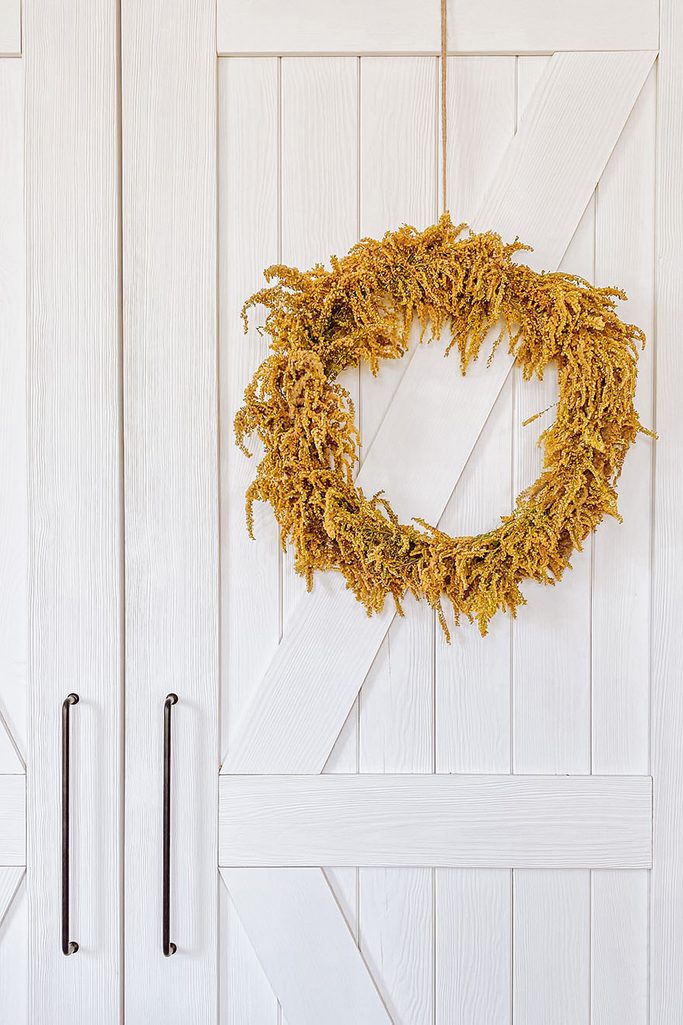 ozdobny wieniec na białych drewnianych drzwiach przesuwnych