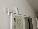 drzwi przesuwne z lustrem w białej metalowej ramie