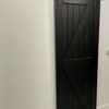 czarne drewniane drzwi przesuwne na białej ścianie