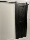 czarne drewniane drzwi przesuwne na białej ścianie