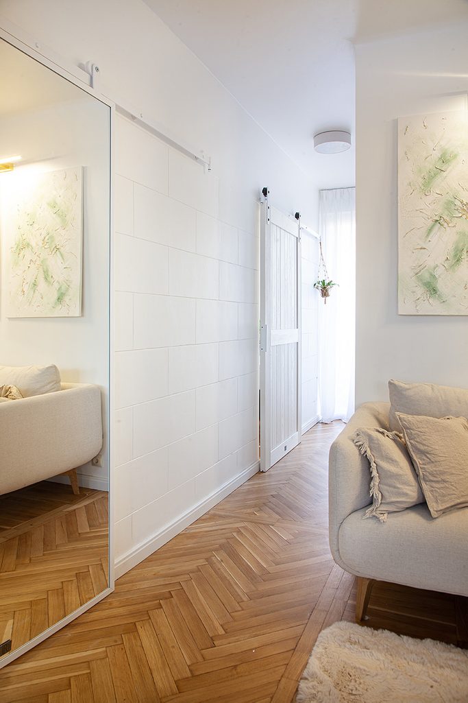 białe drzwi przesuwne w korytarzu małego mieszkania