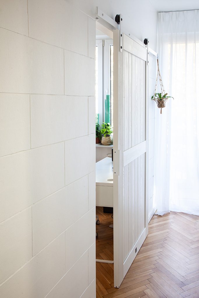 białe drewniane drzwi przesuwne w wąskim korytarzu