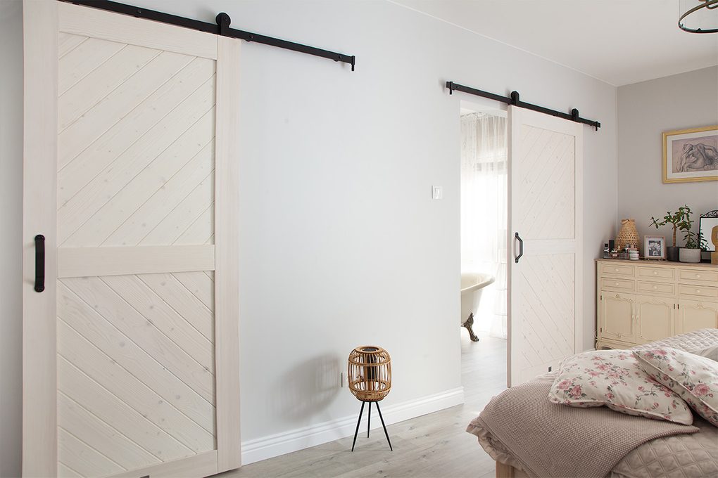 białe drzwi przesuwne do łazienki w sypialni urządzonej w stylu prowansalskim