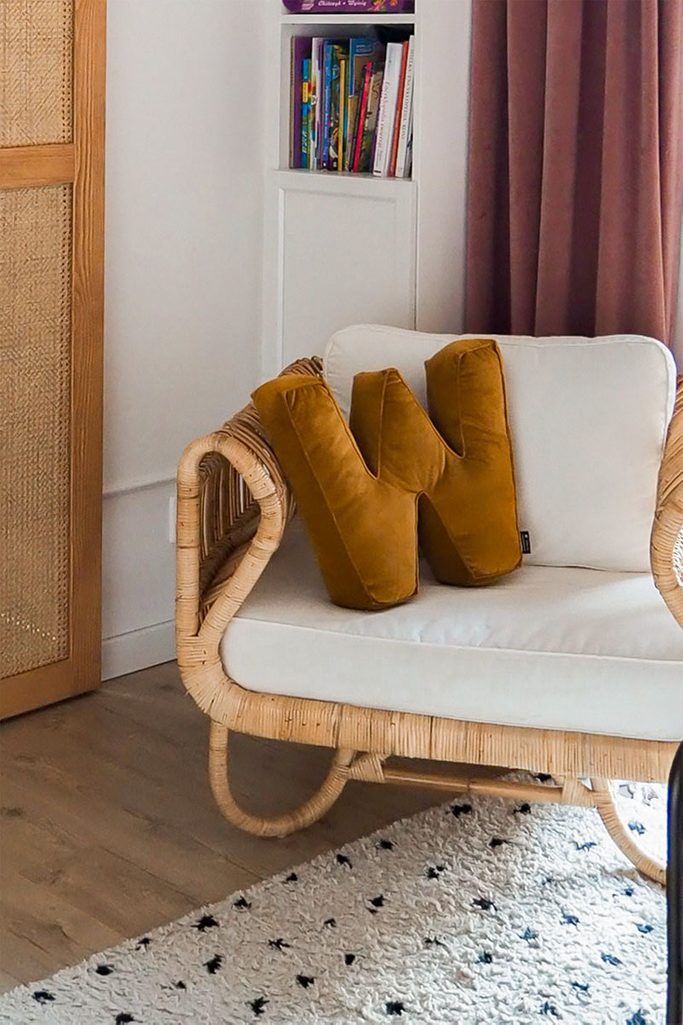 poduszka literka i wiklinowy fotel w pokoju dziewczynki