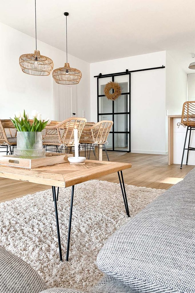 kwadratowy stolik kawowy z naturalnego drewna na metalowych nogach w salonie połączonym z jadalnią