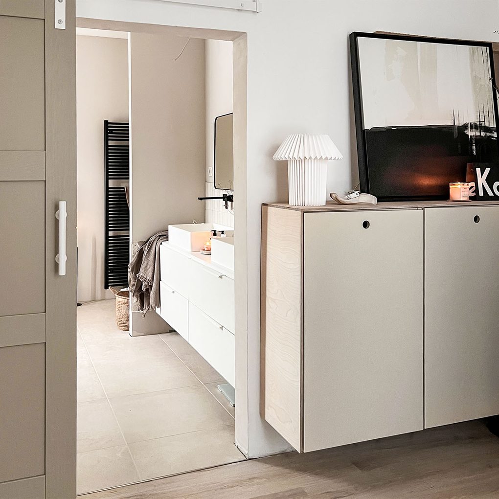 beżowa minimalistyczna komoda przy wejściu do nowoczesnej łazienki