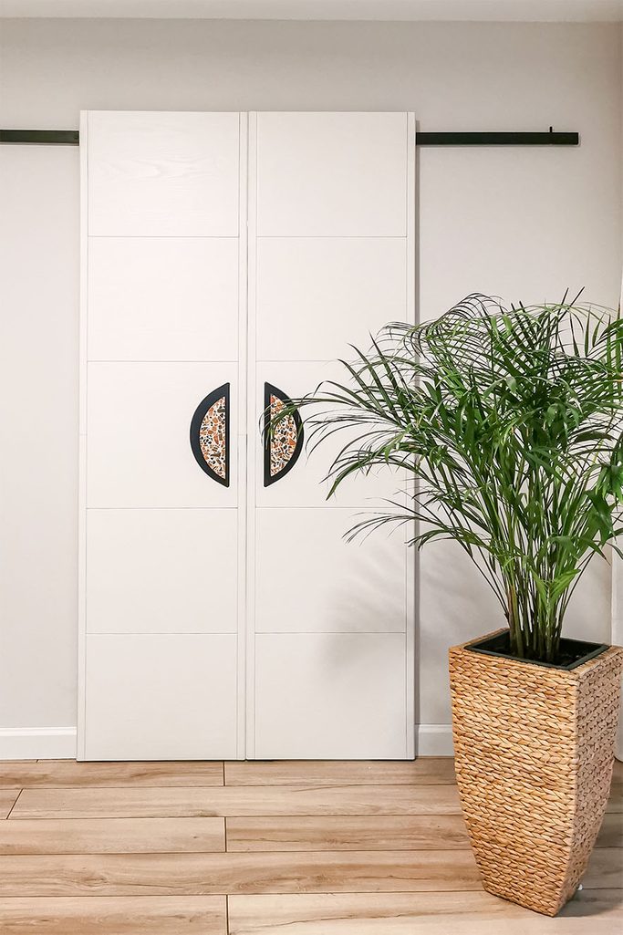 minimalistyczne podwójne drzwi przesuwne w kolorze białym z klamkami w stylu lastryko