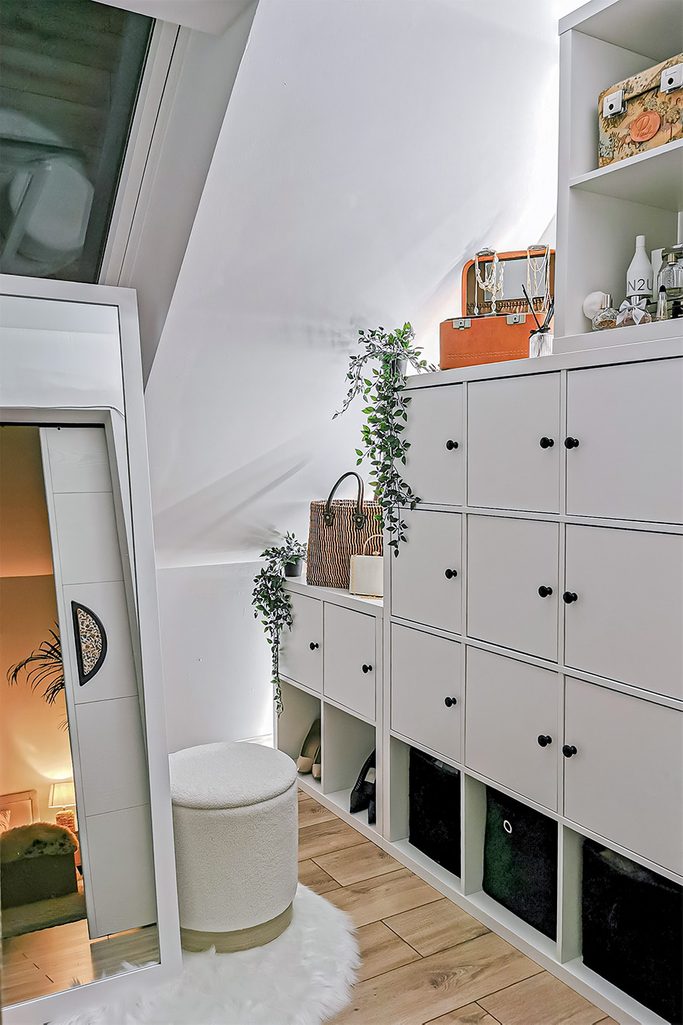 duże lustro w białej ramie oraz białe szafki i półki w garderobie